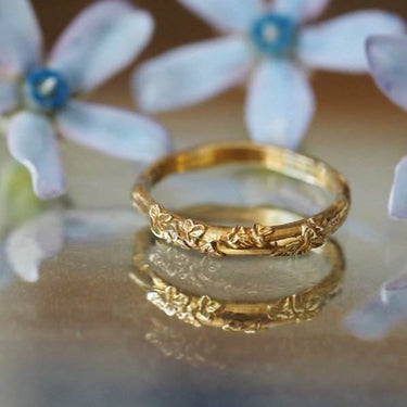 dainty gold wedding band with leaf and vine detail