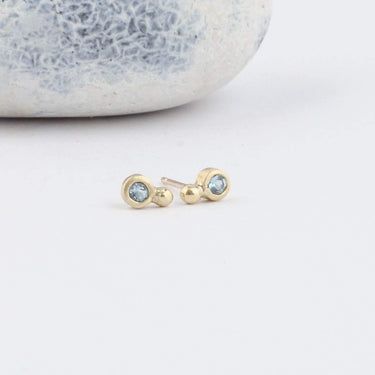 small gold studs with natural aquamarine stones in a bezel setting
